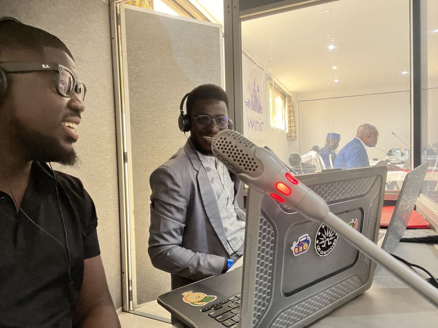 Deux interprètes en cabine pendant une session, micro et ordinateur portable